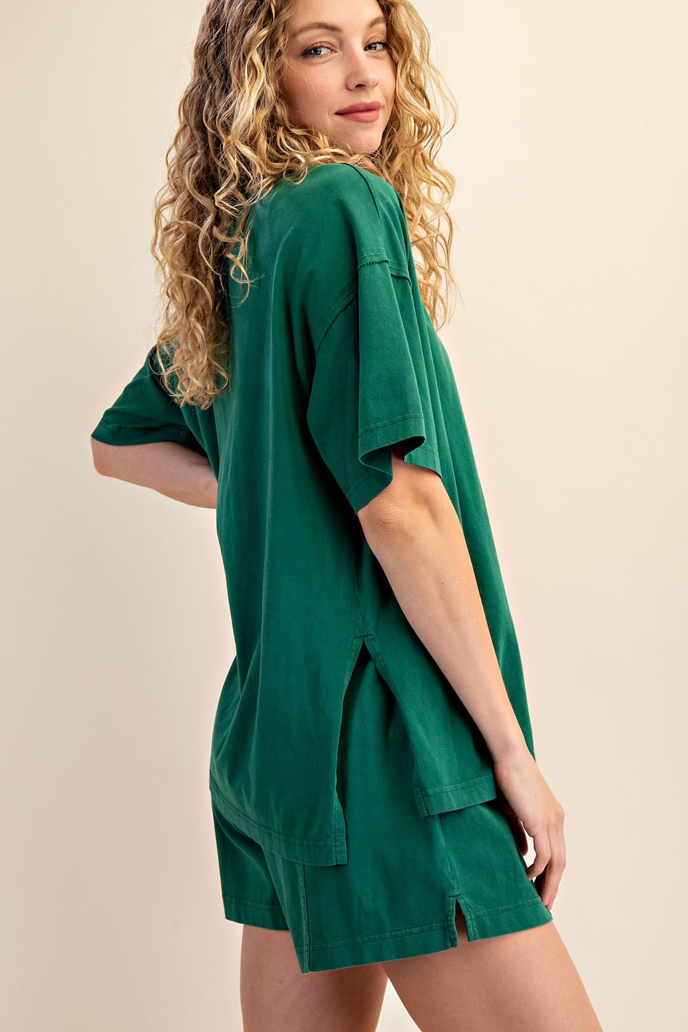 woman wearing a green oversized t-shirt and matching shorts, with side slits, showing a relaxed fit