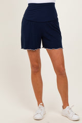 woman wearing navy blue athletic shorts with a ruffled hem and a wide waistband, paired with white sneakers