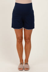 woman wearing navy blue maternity shorts with scalloped hem and a supportive waistband, featuring a visible baby bump