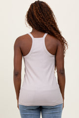 woman wearing a light taupe ribbed tank top and blue jeans, showing the back view of the top