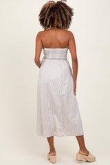woman wearing a striped strapless maternity dress with a smocked bodice, showing off her baby bump from the back