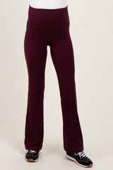 woman wearing burgundy maternity yoga pants with a flared leg style