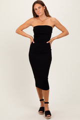 woman wearing a black strapless midi dress with a fitted silhouette and posing with hands on hips