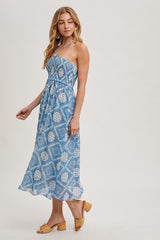 woman wearing a blue patterned maxi dress with adjustable straps and a flowing skirt