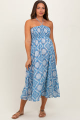 woman wearing a blue patterned strapless maternity dress with a flowing silhouette and a fitted bodice