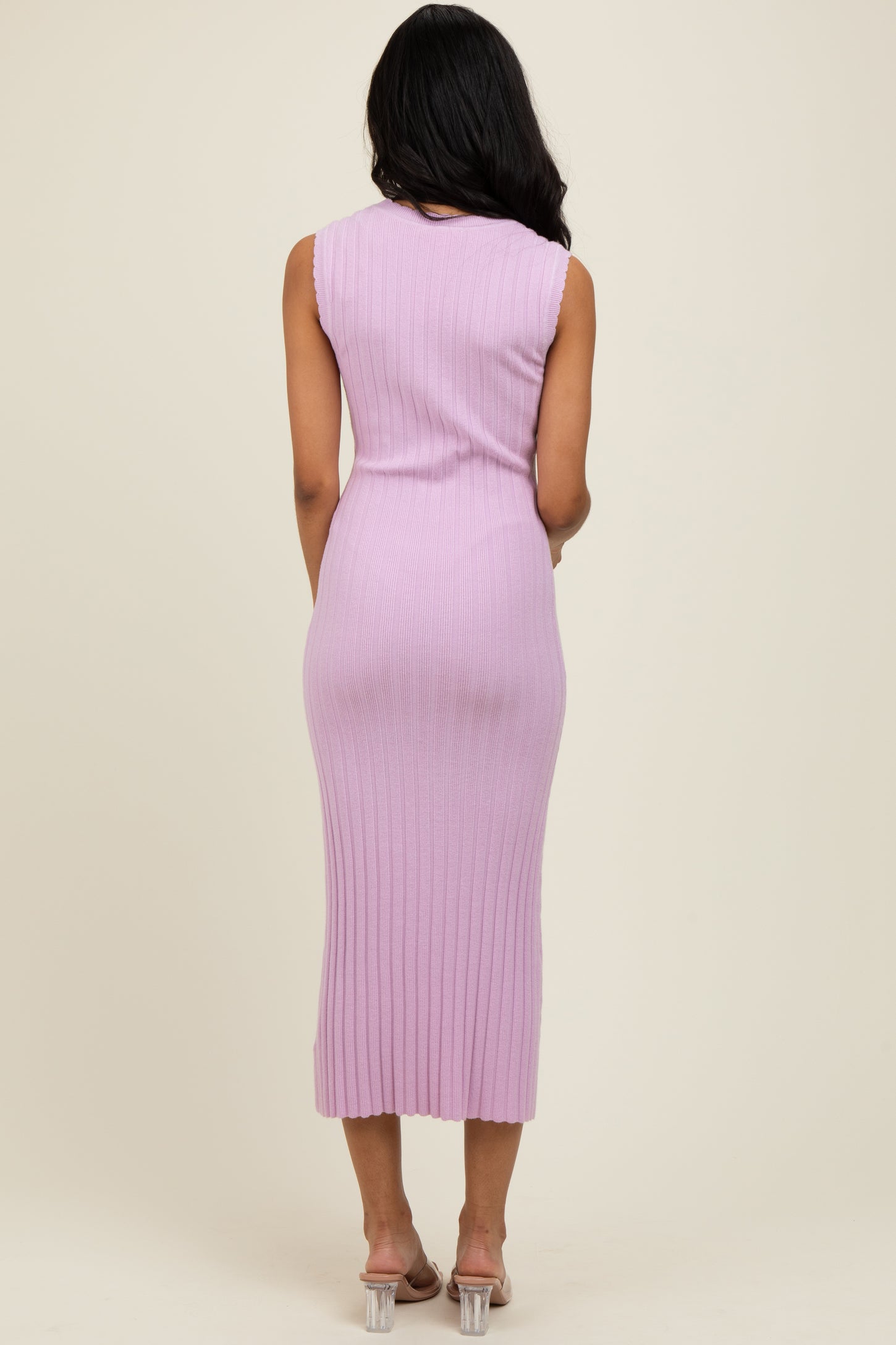 woman wearing a lavender sleeveless ribbed midi dress, back view, with a fitted silhouette and a side slit