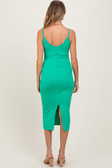 woman wearing a green ribbed midi maternity dress with a back slit and adjustable straps