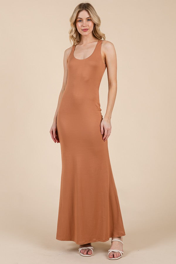 woman wearing a rust-colored sleeveless maxi dress with a fitted silhouette and a flared hem