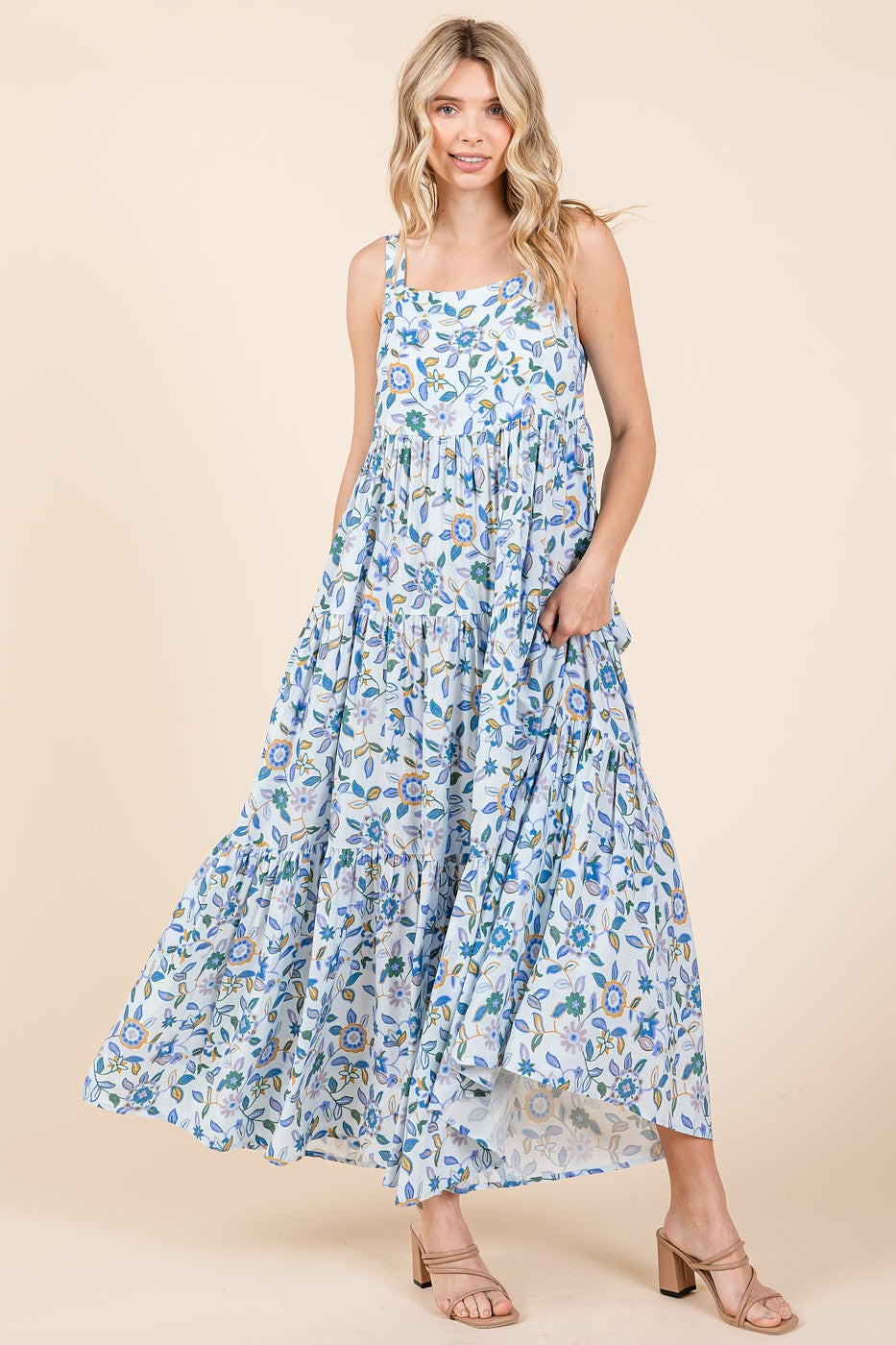woman wearing a light blue floral maxi dress with tiered ruffles and a flowing skirt.