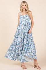 woman wearing a light blue floral maxi dress with tiered ruffles and a flowing skirt.