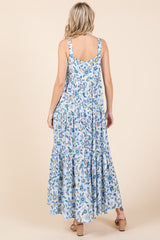 woman wearing a blue and white floral maxi dress with a tiered skirt, viewed from the back