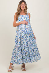 woman wearing a floral maxi maternity dress and holding her baby bump