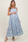 woman wearing a floral maxi maternity dress and holding her baby bump