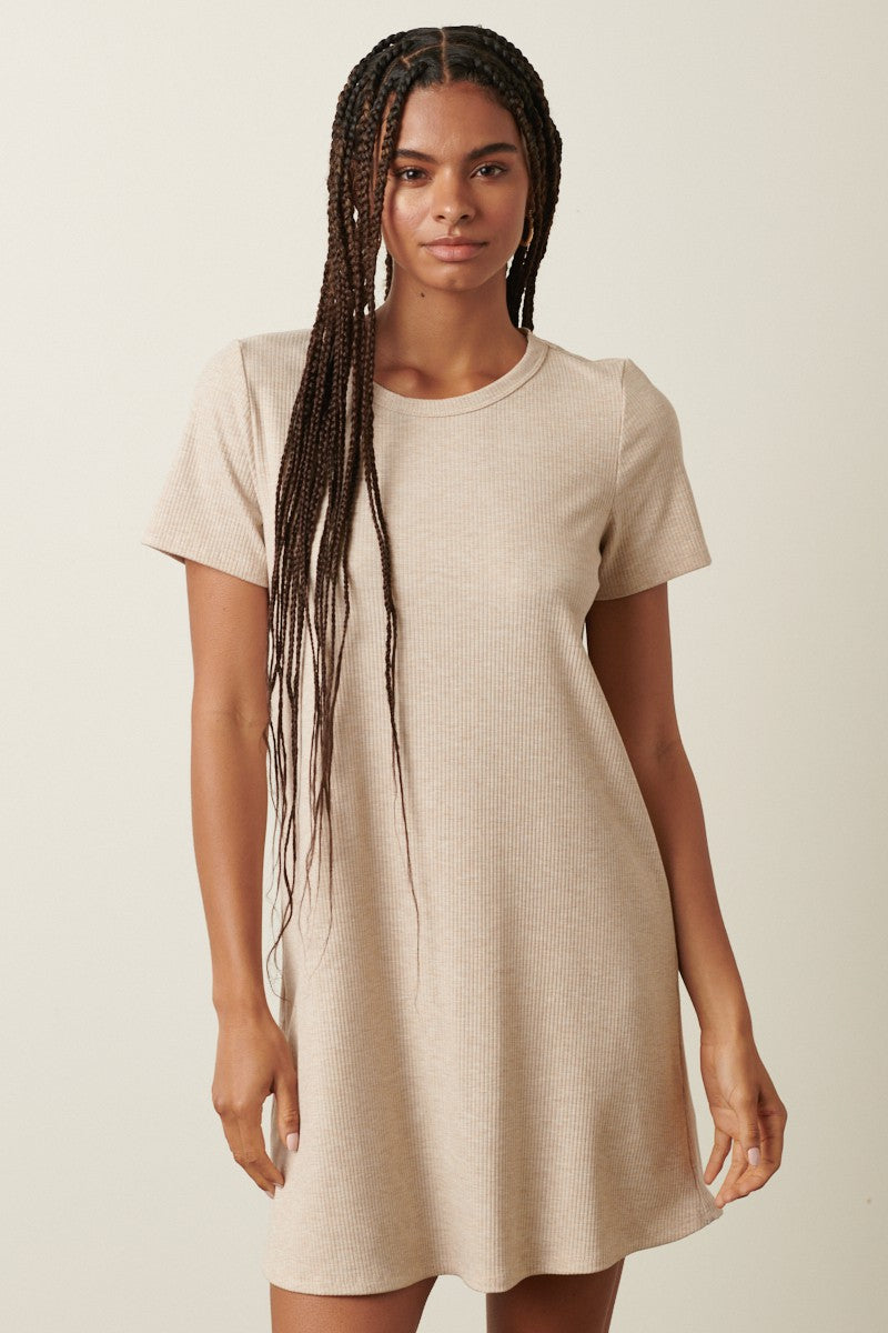 woman wearing a short sleeve ribbed beige dress with a relaxed fit and a round neckline