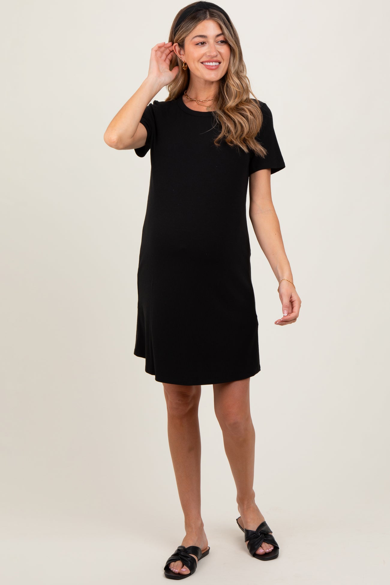 woman wearing a black short sleeve maternity dress with a relaxed fit and a baby bump visible