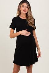 woman wearing a black short sleeve maternity dress and holding her baby bump