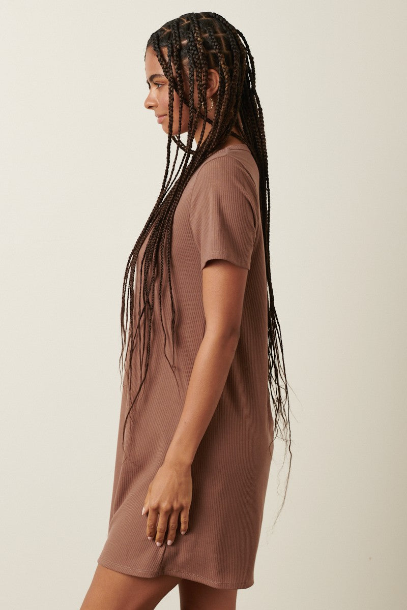 woman wearing a brown ribbed short sleeve dress with a relaxed fit, styled with long braids