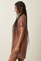 woman wearing a brown ribbed short sleeve dress with a relaxed fit, styled with long braids