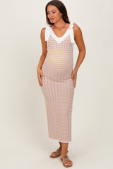 woman wearing a patterned maternity maxi dress with white straps and a v-neckline, highlighting her baby bump