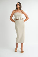 woman wearing a beige strapless ribbed two-piece set with a ruffled crop top and a midi skirt