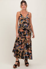 woman wearing a black floral maternity maxi dress featuring adjustable straps and a fitted bodice with a baby bump visible