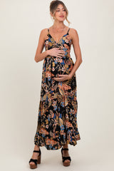 woman wearing a black floral maternity maxi dress and holding her baby bump