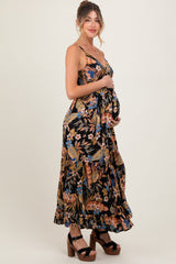 woman wearing a black floral maxi maternity dress and holding her baby bump
