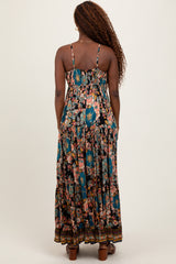 woman wearing a black floral maxi dress with spaghetti straps and tiered detailing, viewed from the back