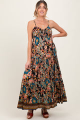 woman wearing a black floral maxi maternity dress with adjustable straps and a flowy skirt, showcasing her baby bump