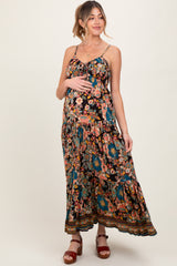 woman wearing a black floral maternity maxi dress and cradling her baby bump
