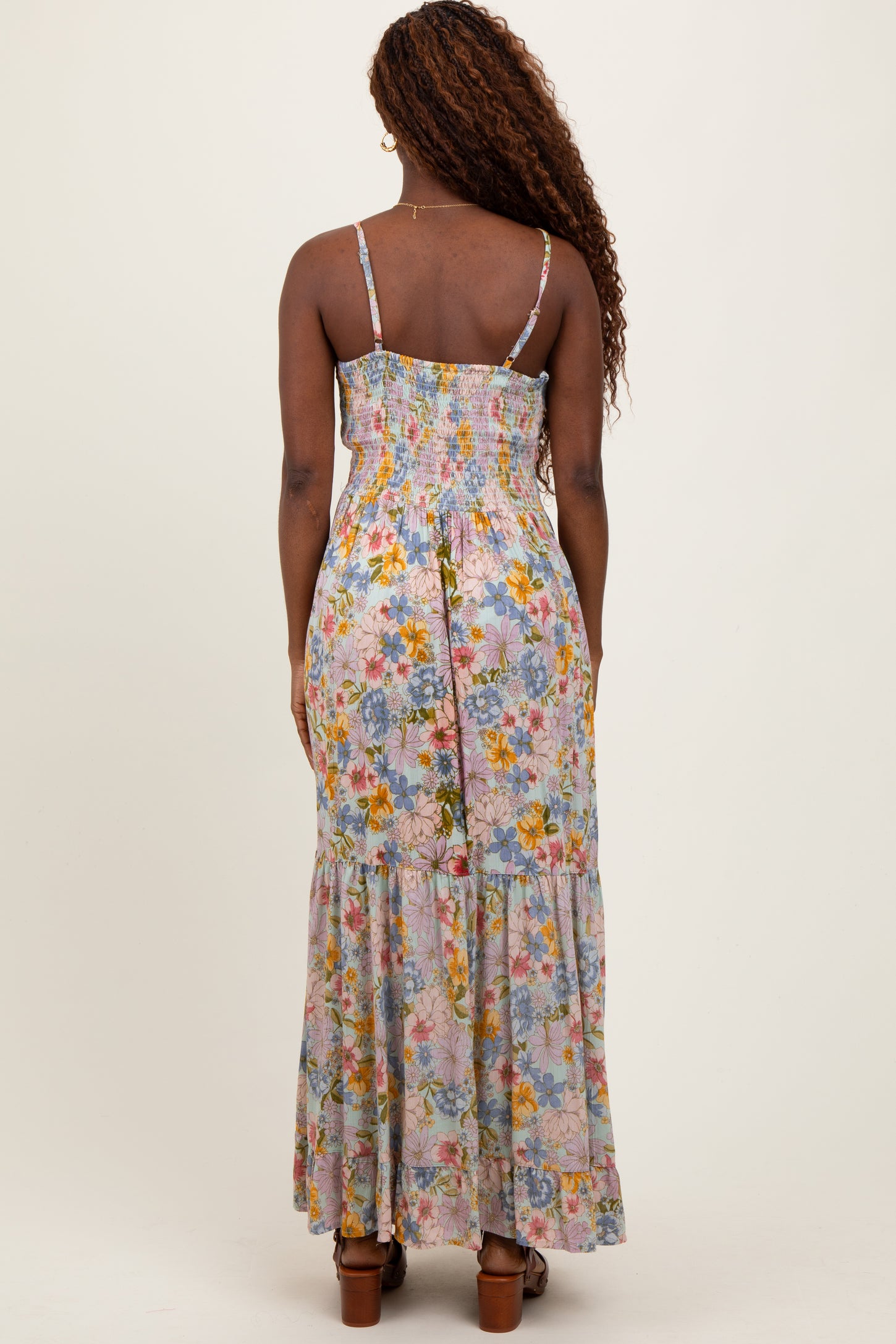 woman wearing a back view of a floral print maxi dress with a smocked bodice and tiered skirt