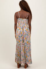 woman wearing a back view of a floral print maxi dress with a smocked bodice and tiered skirt