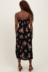 woman wearing a black floral midi dress with a smocked bodice and thin straps, seen from the back