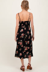 woman wearing a black floral maternity dress with adjustable straps and a flowing skirt, viewed from the back