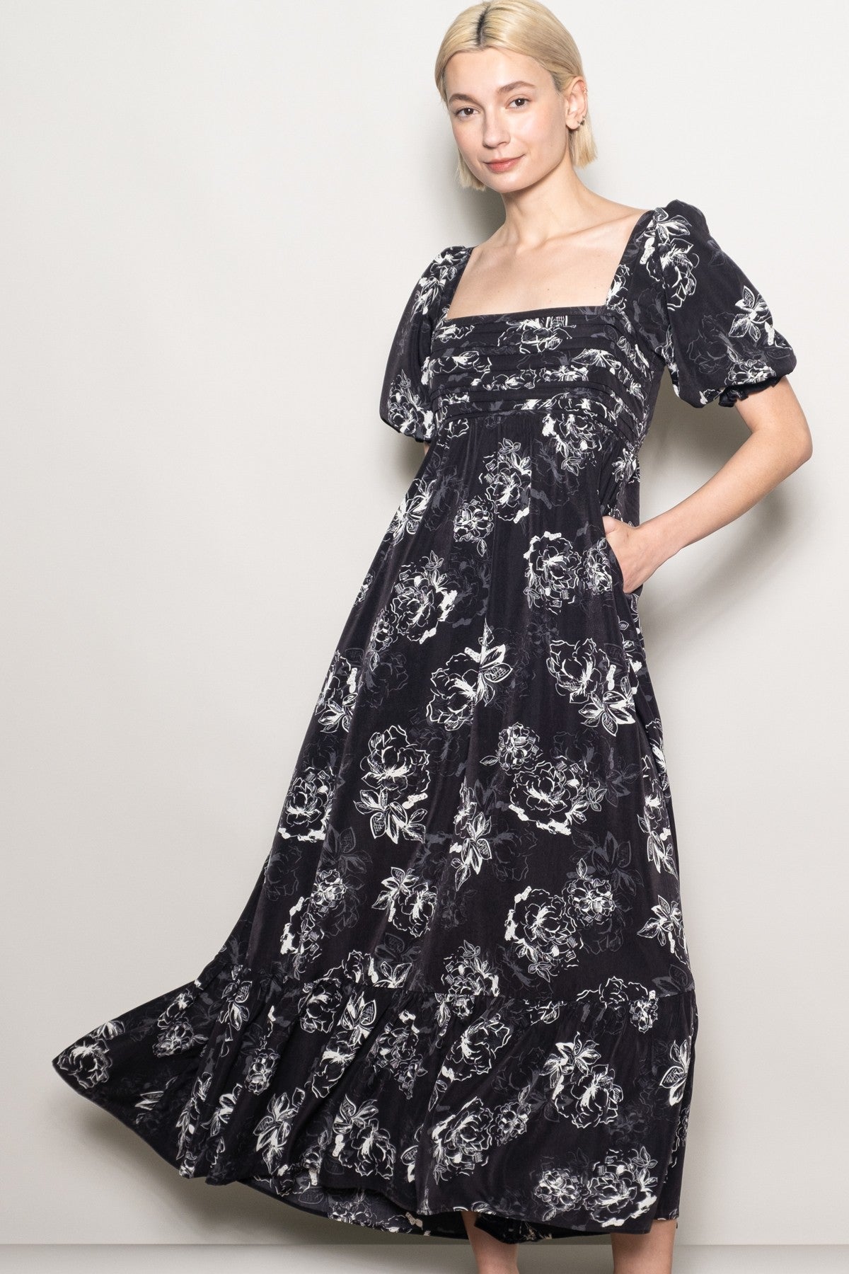 woman wearing a black floral maxi dress with puff sleeves and pockets