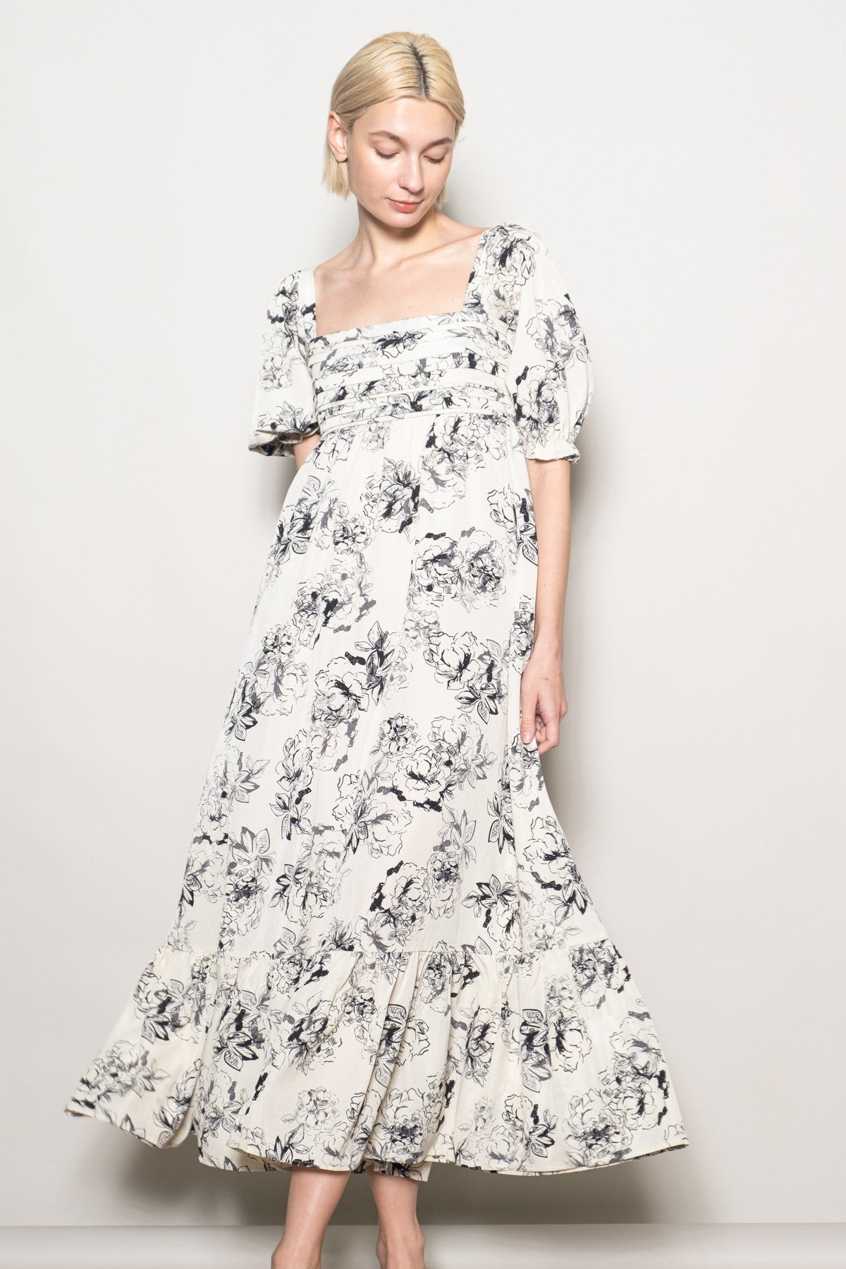 woman wearing a white floral maxi dress with puff sleeves and a square neckline