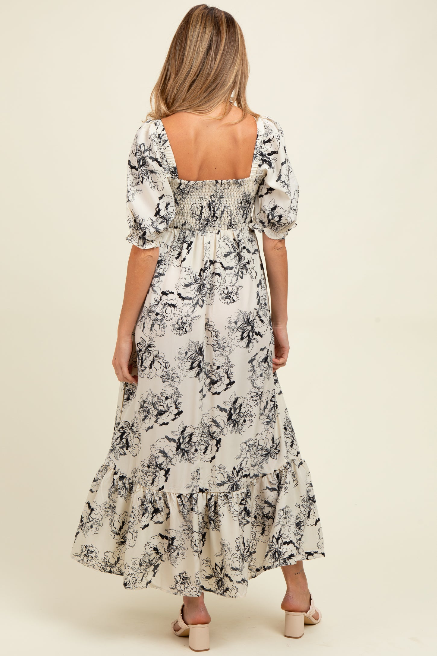 woman wearing a floral print maternity maxi dress with puffy sleeves and smocked back details