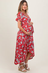 woman wearing a red floral maternity dress with flutter sleeves and a baby bump visible, standing in profile