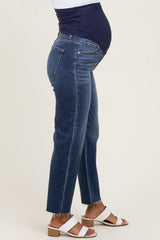 woman wearing a pair of blue maternity jeans with a navy belly band and frayed hem, showing her baby bump