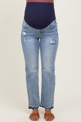 woman wearing distressed light blue maternity jeans with a dark blue over-the-belly waistband and brown sandals