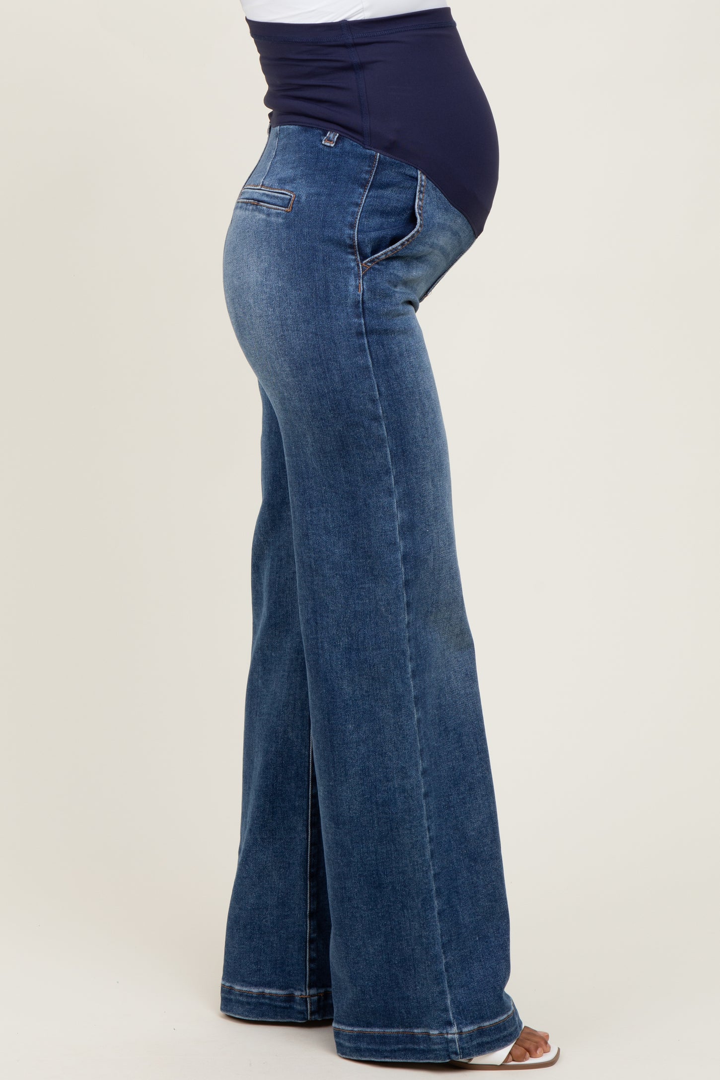 maternity wear blue denim flared jeans with a stretchy belly panel and visible baby bump