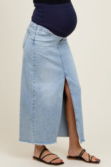 woman wearing a light wash maternity maxi denim skirt with a front slit and showing her baby bump