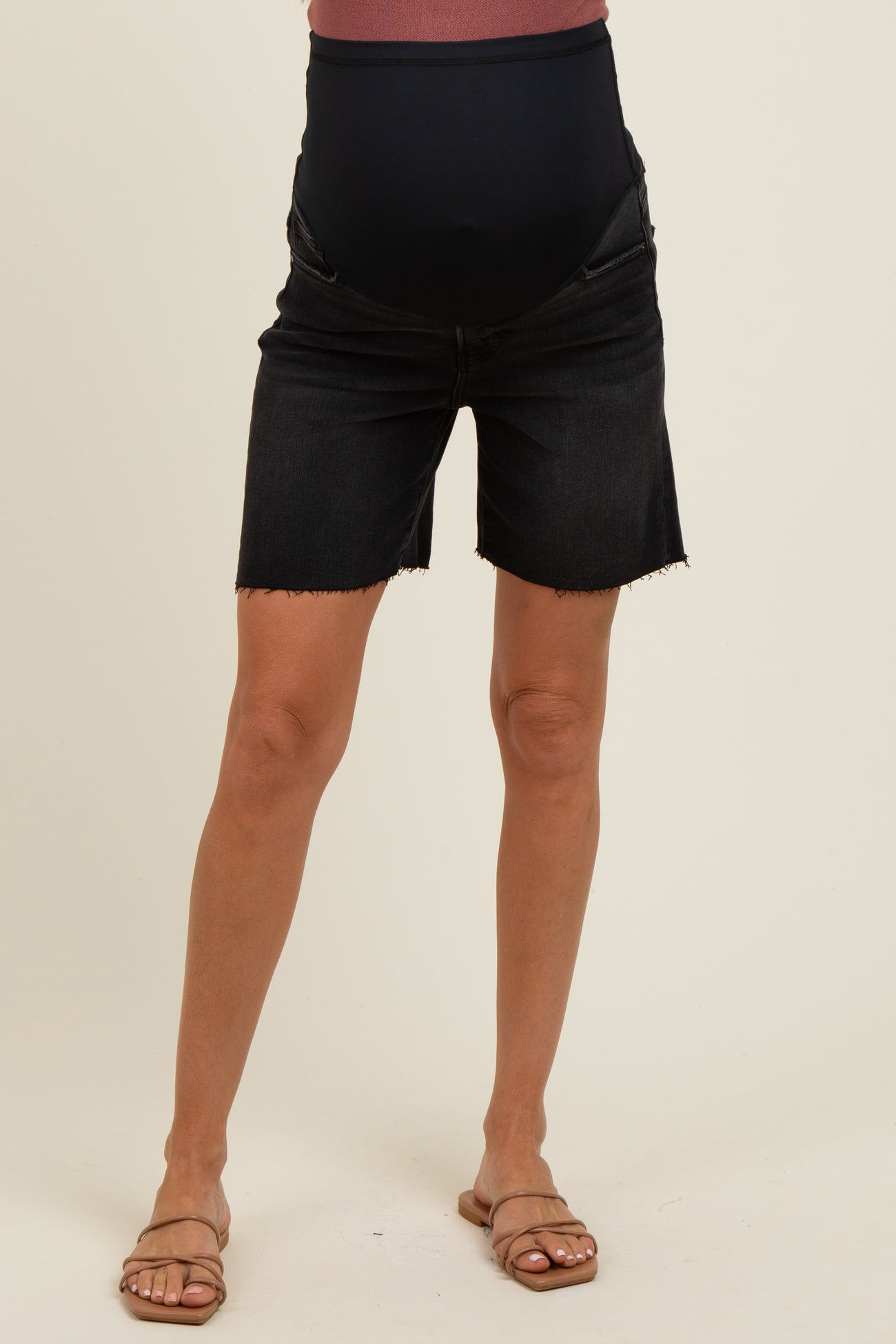 woman wearing black maternity denim shorts with a stretchy waistband and a visible baby bump