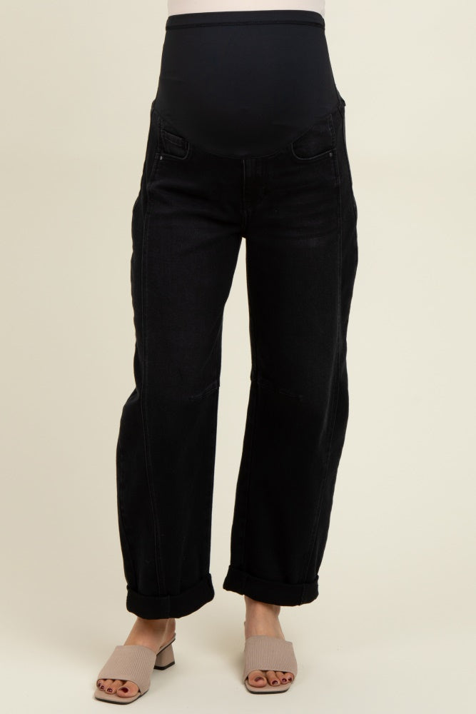 woman wearing black maternity jeans with a beige stretchy belly panel and rolled cuffs, showcasing a baby bump