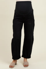 woman wearing black maternity jeans with a beige stretchy belly panel and rolled cuffs, showcasing a baby bump