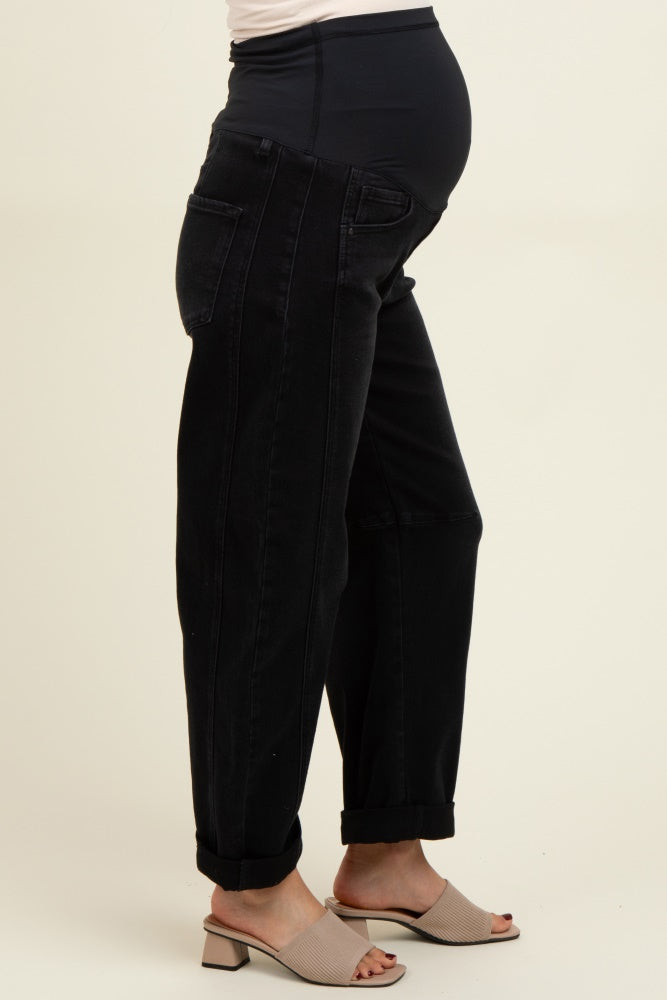 woman wearing black maternity jeans with a high waistband and a relaxed fit, showing a baby bump