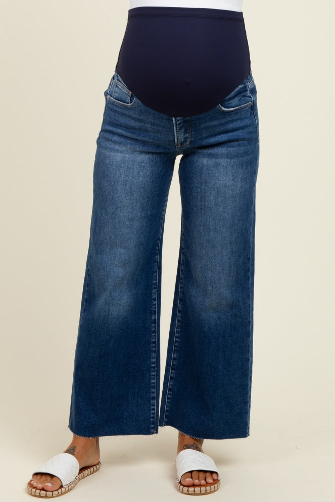 woman wearing dark blue wide-leg maternity jeans with a navy panel and white slide sandals