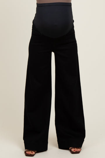 woman wearing black wide-leg maternity pants with a supportive belly band