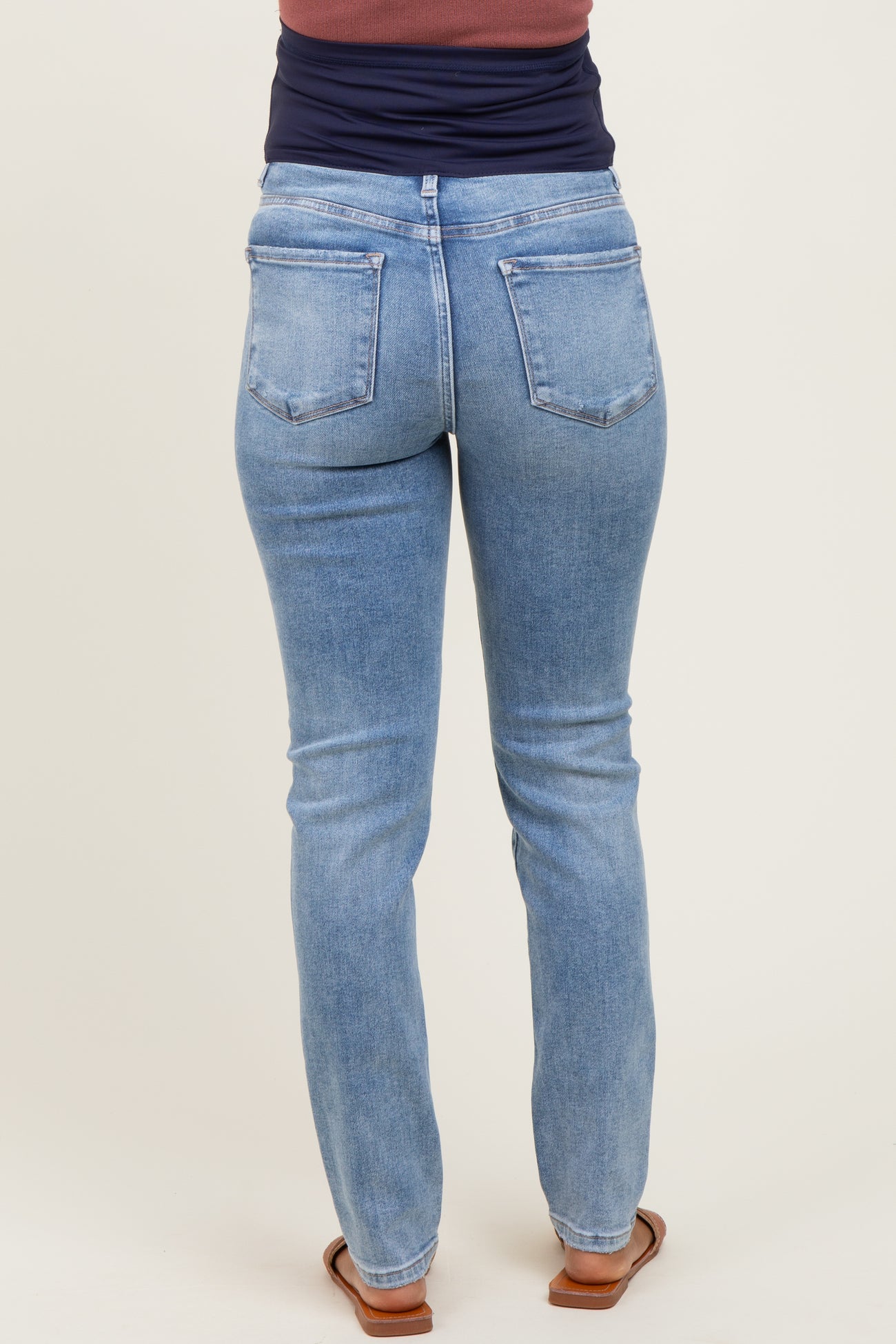 maternity wear light blue skinny jeans shown from the back, featuring a classic five-pocket design