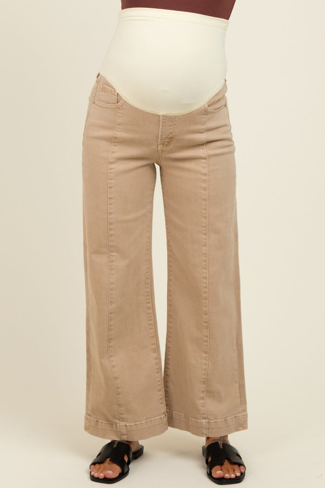 woman wearing beige maternity wide-leg jeans with a stretchy over-the-bump waistband and black sandals.